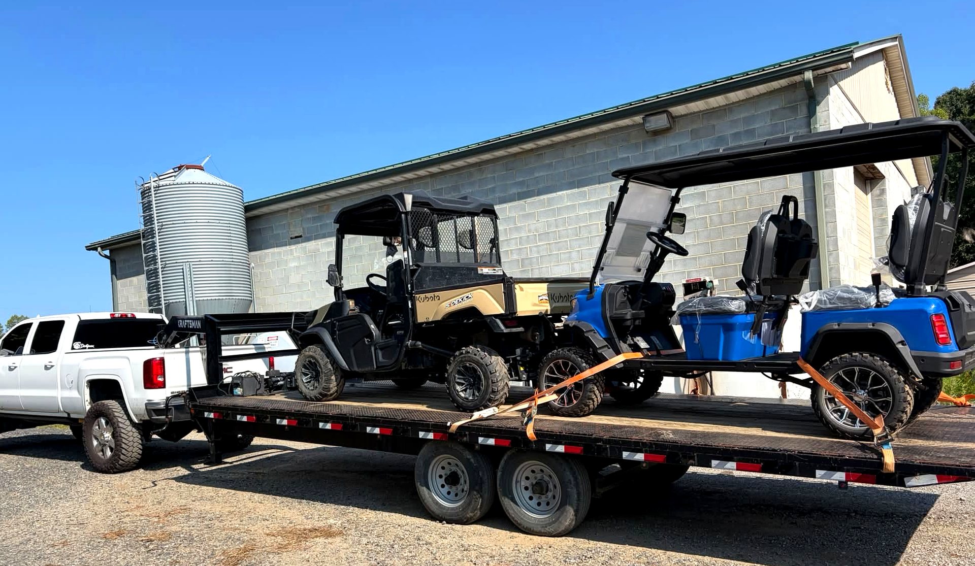Gooseneck trailer loaded with a side-by-side and golf cart, hitched and ready to roll