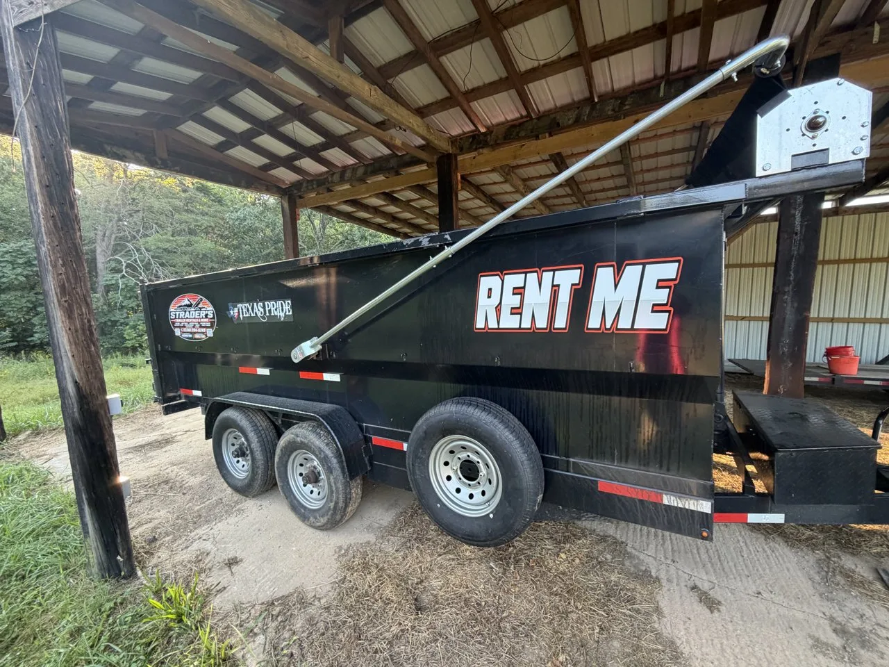 Black 7x16 dump trailer with RENT ME lettering and a mounted spare tire